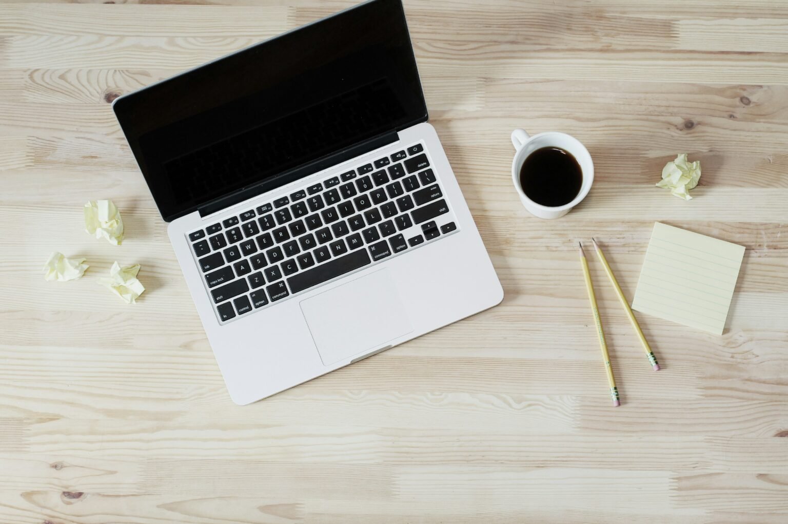 Bureau d'un ergothérapeute avec ordinateur, tasse de café, post-it et crayon, illustrant les activités administratives et de planification des séances